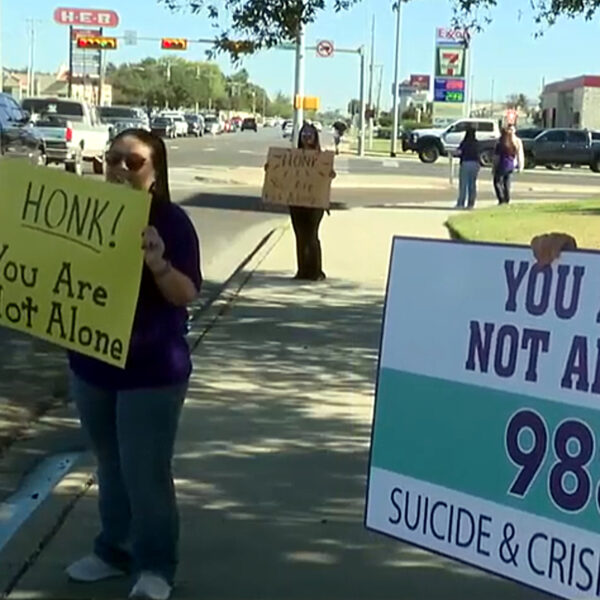 Manifestación con pancartas de apoyo a la salud mental y promoción del número 988 en Laredo Texas.