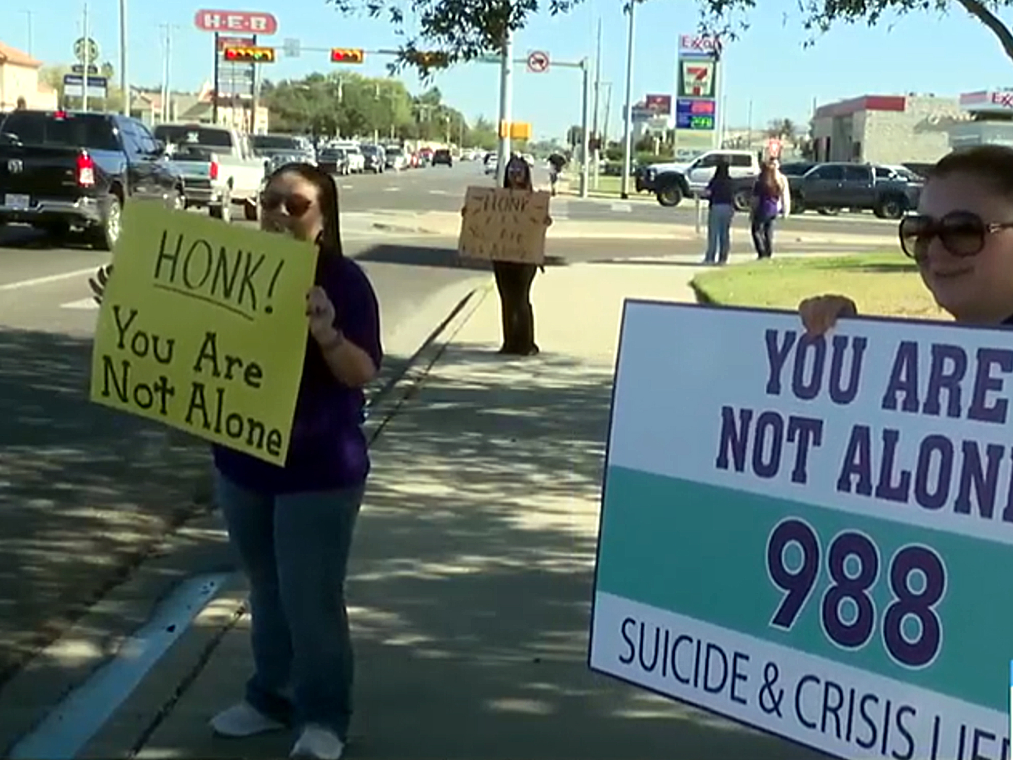 Manifestación con pancartas de apoyo a la salud mental y promoción del número 988 en Laredo Texas.