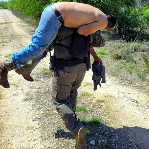 Agente fronterizo de Encinal carga a migrante deshidratado en zona rural