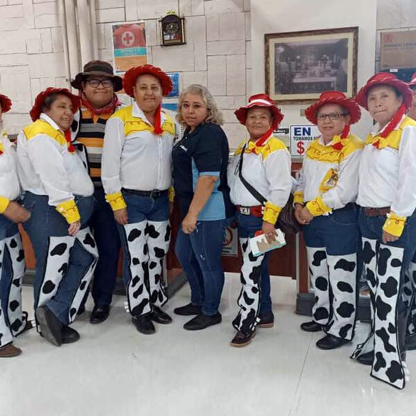 Grupo de empacadoras vestidas como Jessie posando junto a compañeros y encargados en Smart Colinas por el Día del Niño.