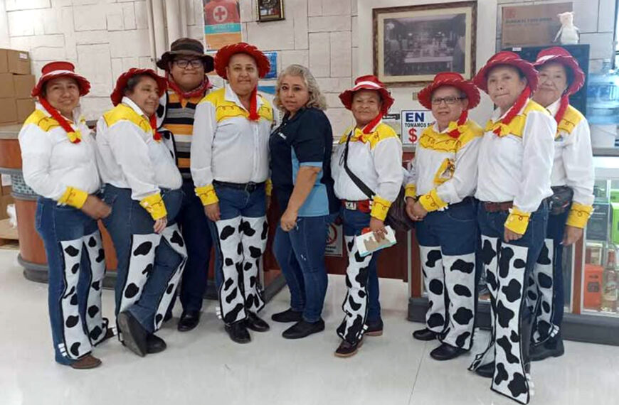Grupo de empacadoras vestidas como Jessie posando junto a compañeros y encargados en Smart Colinas por el Día del Niño.