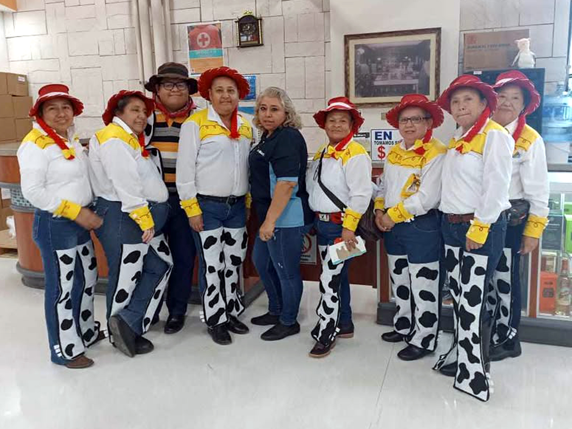 Grupo de empacadoras vestidas como Jessie posando junto a compañeros y encargados en Smart Colinas por el Día del Niño.