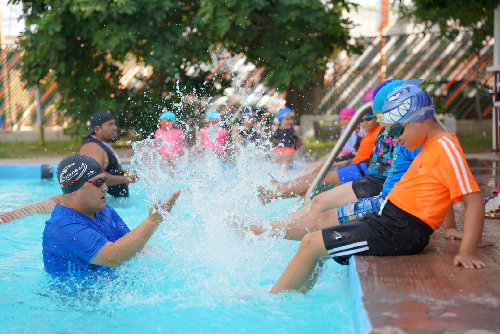 Curso de natación en Nuevo Laredo con niños, jóvenes y adultos participando activamente en la alberca de la Unidad Benito Juárez