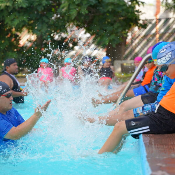 Curso de natación en Nuevo Laredo con niños, jóvenes y adultos participando activamente en la alberca de la Unidad Benito Juárez
