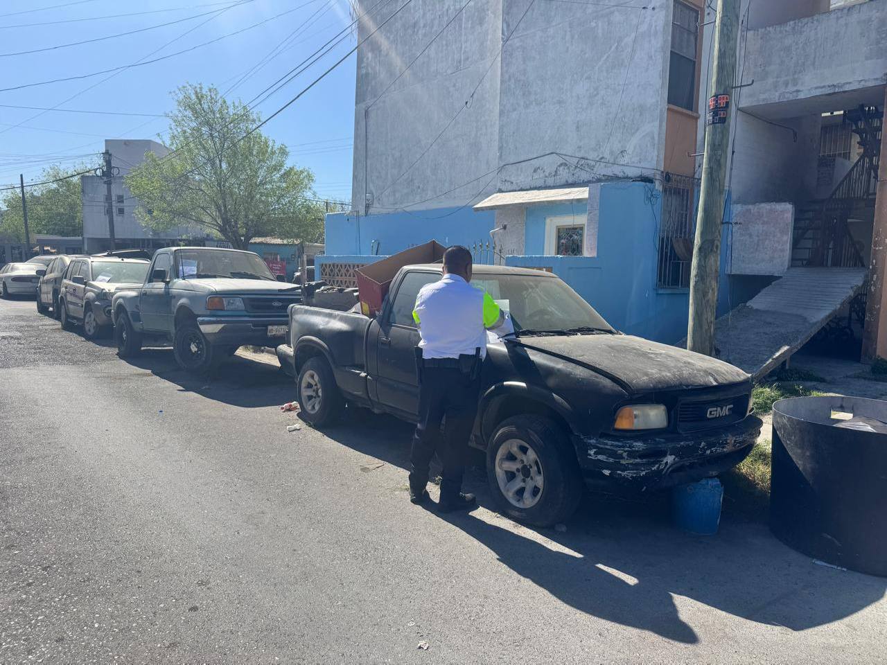 Camión de grúa retirando un vehículo abandonado en colonia del poniente de Nuevo Laredo como parte del programa de deschatarrización