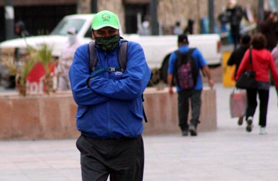 Persona abrigada caminando en la calle durante clima frío en Nuevo Laredo, en el contexto de los frentes fríos y ondas gélidas pronosticados.