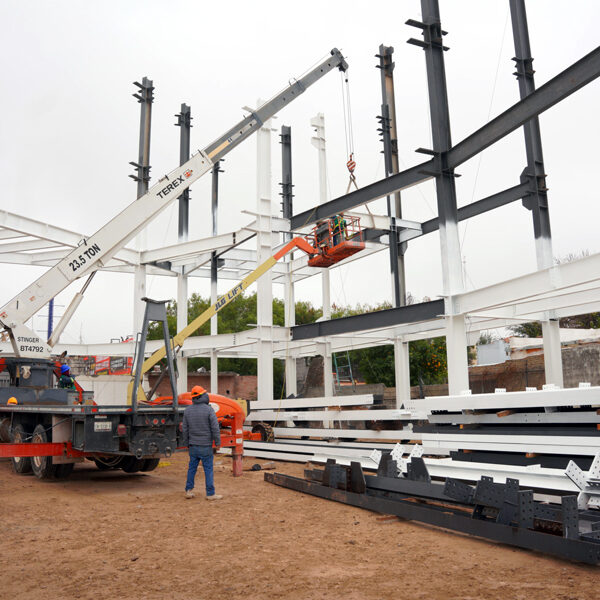 Construcción del Museo de Ciencia y Tecnología en Nuevo Laredo con montaje de estructura metálica y trabajadores en obra.