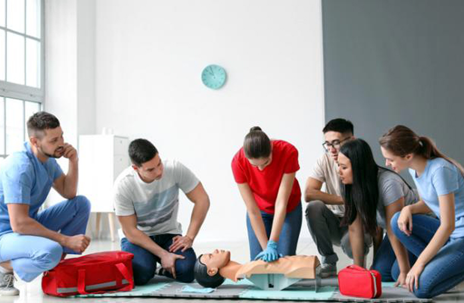 Grupo de personas aprendiendo primeros auxilios y RCP con un maniqu durante un taller prctico