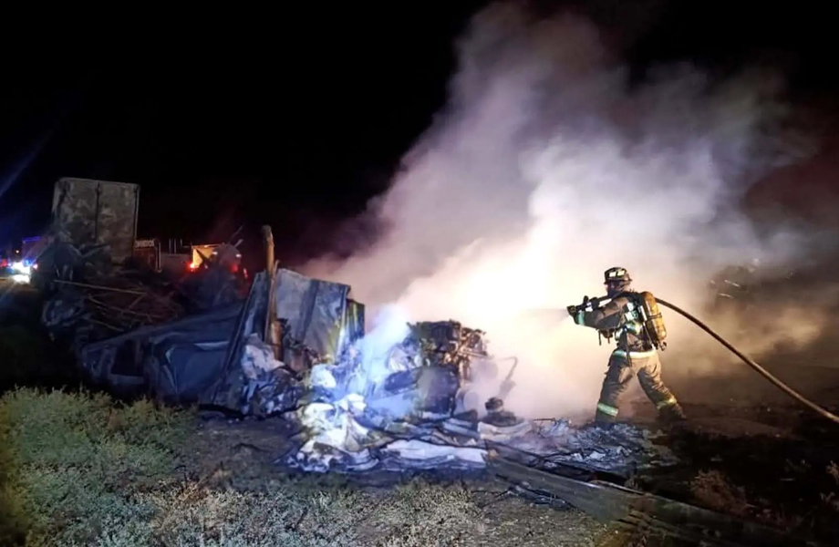 Bombero combate incendio de tráiler calcinado durante la madrugada en la carretera Monterrey–Nuevo Laredo.