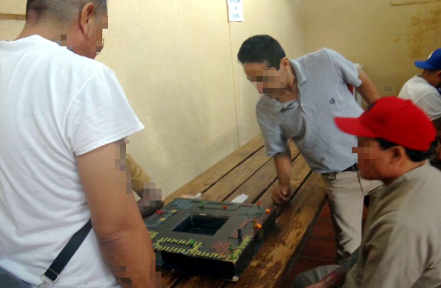 Acercamiento al tablero de poleana, con fichas y dados sobre la mesa de madera dentro del CEDES Nuevo Laredo.