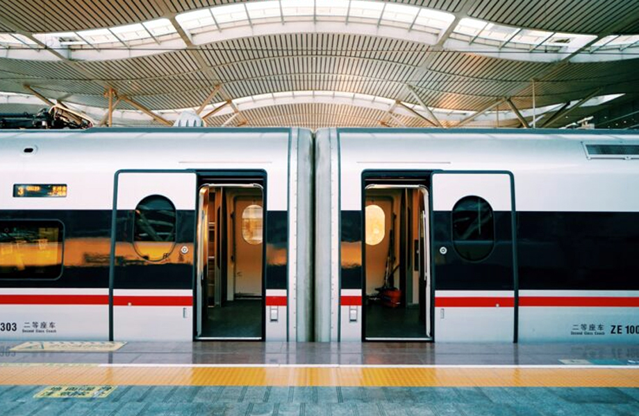 Tren de pasajeros de dos coches con puertas abiertas en una estacin cubierta listo para abordar