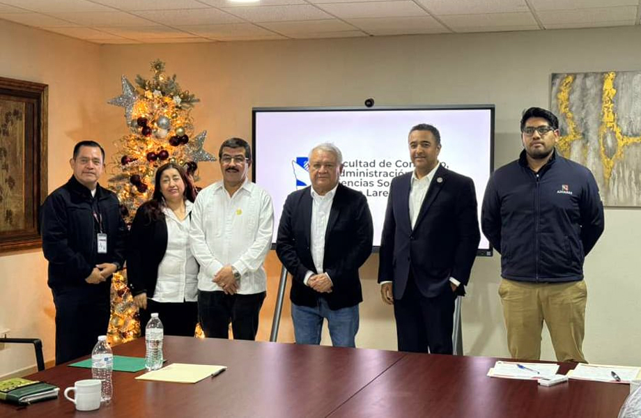 Rector de la UAT y directivos de la ANAM posan frente a una pantalla de la Facultad de Comercio de Nuevo Laredo junto a un rbol de Navidad