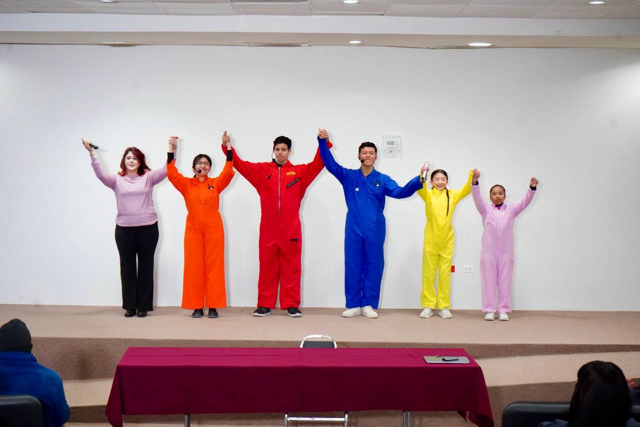 Jvenes actores con overoles de colores levantan las manos al final de una obra de teatro sobre inclusin en el CRI