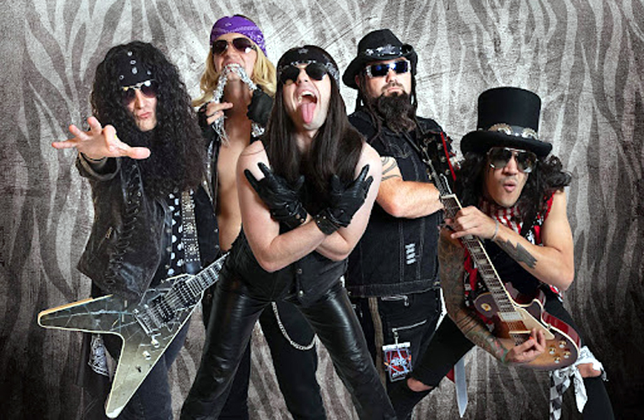 Miembros de That Arena Rock Show con ropa de cuero negro y guitarras elctricas frente a un fondo con estampado de cebra en estilo rock ochentero