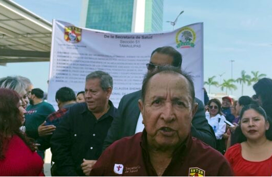Vocero sindical del Sector Salud habla frente a una manta de protesta en la explanada de la Torre Bicentenario.