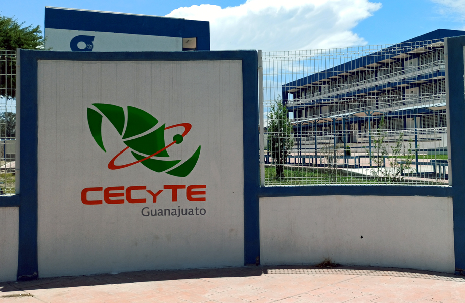 Entrada de un plantel CECyTE Guanajuato con el logotipo en un muro blanco y azul y el edificio escolar al fondo
