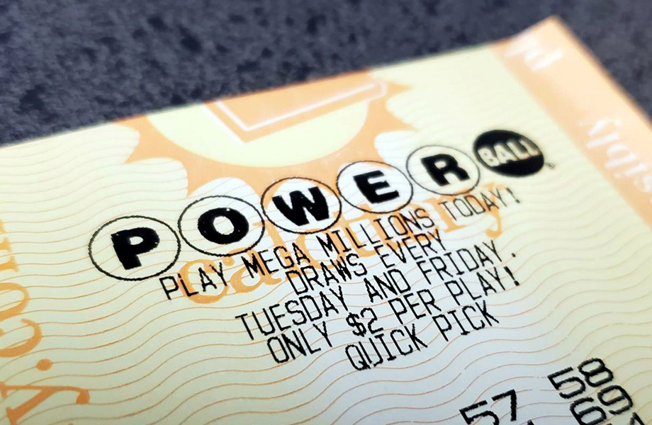 Primer plano de un boleto de Powerball con el logo del juego y texto impreso sobre el costo de 2 dólares por cada jugada.