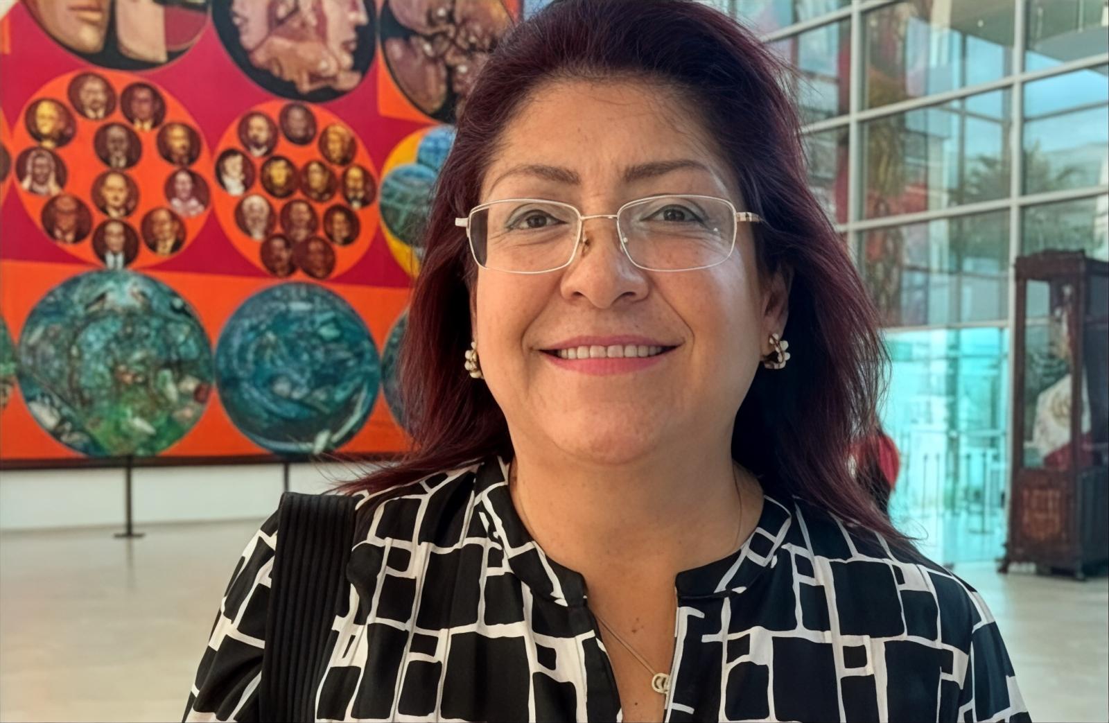 Mujer con lentes en interior con mural en contexto de discusin sobre peajes y carreteras concesionadas