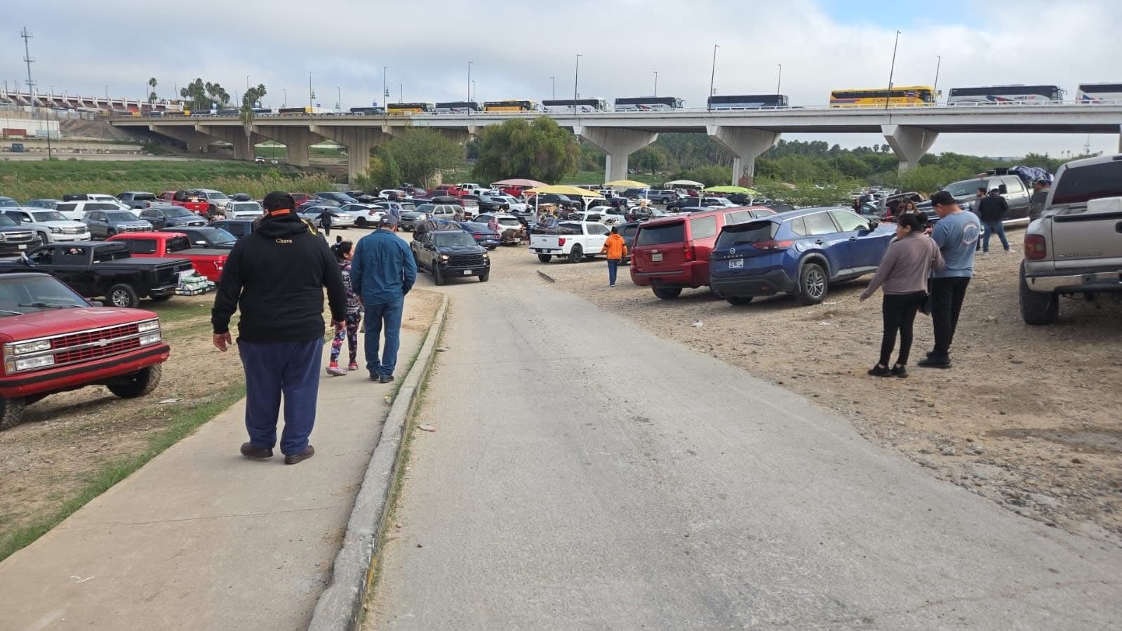 Paisanos caminan cerca del cruce fronterizo de Nuevo Laredo