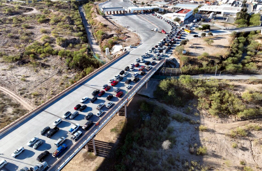Vehículos ligeros forman largas filas para cruzar por el puente internacional Puerto Colombia–Laredo, en la frontera entre Nuevo León y Texas.