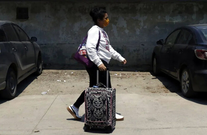 Persona migrante camina con una maleta durante un proceso de salida voluntaria de Estados Unidos.