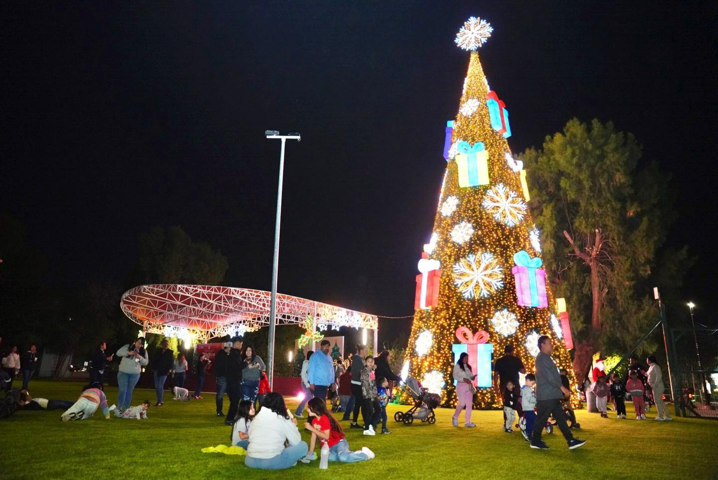 rbol navideo iluminado en el Viveros Mgico de Nuevo Laredo con familias disfrutando del evento decembrino