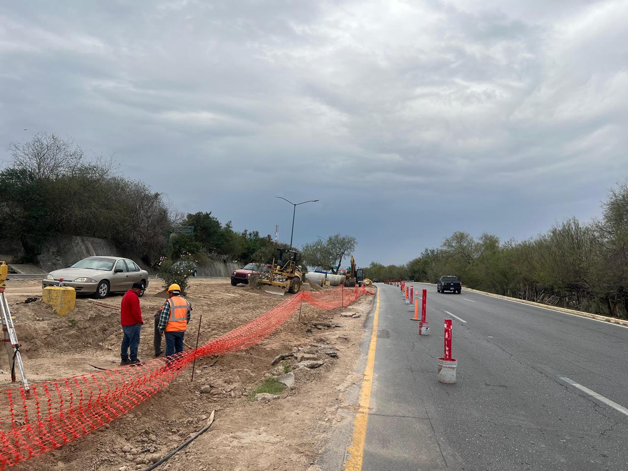 Trabajos de rehabilitación del Colector Ribereño en el bulevar Colosio de Nuevo Laredo con cierre de un carril y maquinaria pesada en operación.