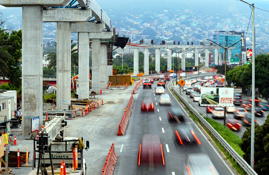 Viaducto del Metro de Monterrey en construcción sobre avenida con tráfico vehicular en Nuevo León