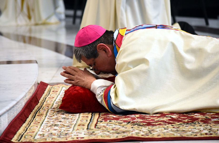 Monseñor Luis Carlos Lerma Martínez postrado en oración durante su ordenación episcopal en la Catedral del Espíritu Santo de Nuevo Laredo.