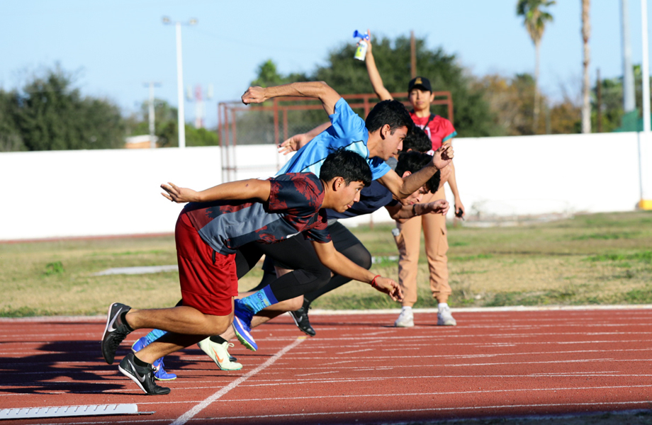 Jóvenes corredores arrancan desde los bloques de salida en la pista de la Unidad Deportiva Benito Juárez.