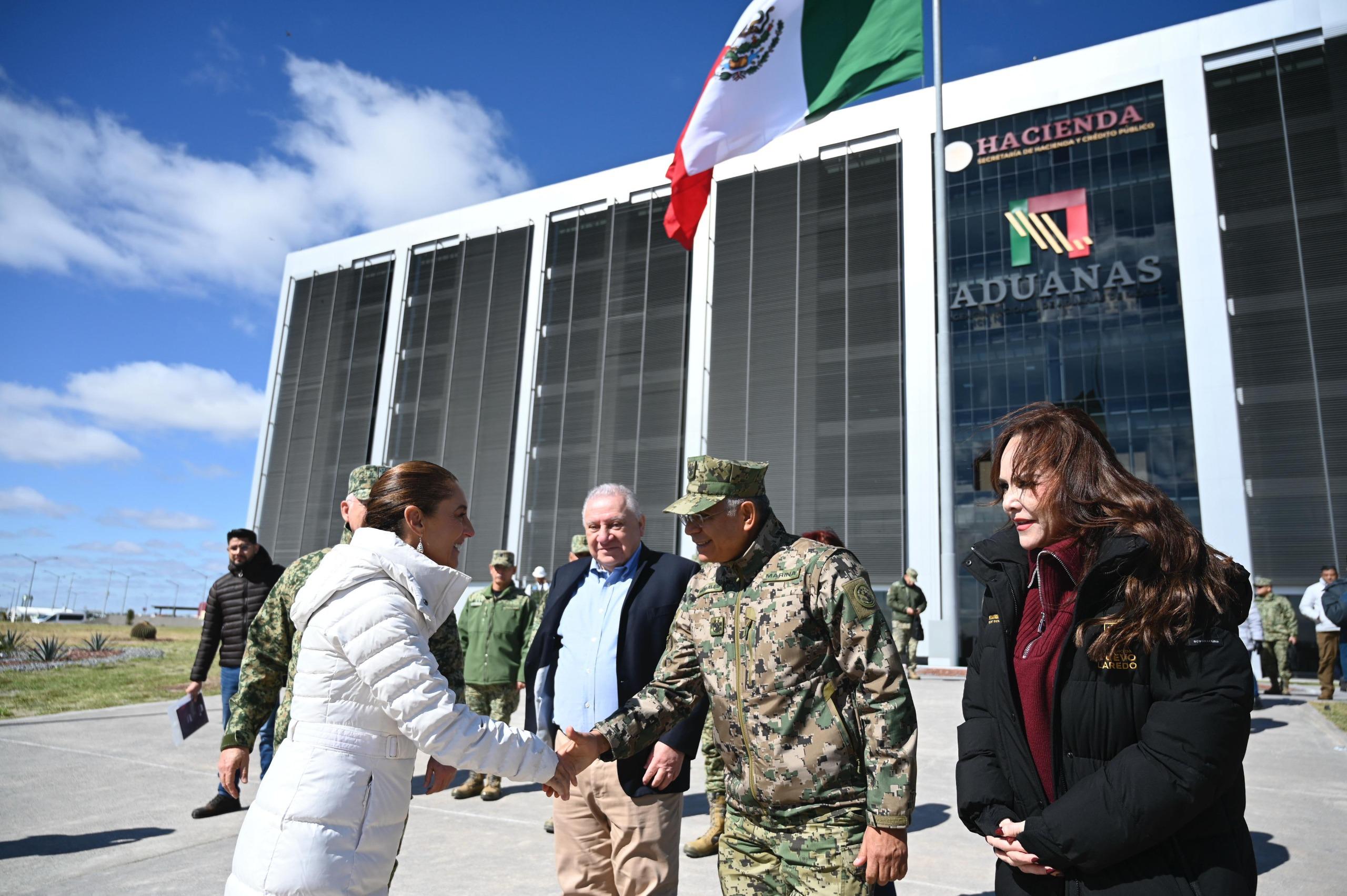 Recorrido inaugural en la sede de Aduanas en Nuevo Laredo donde se observa a la presidenta Claudia Sheinbaum saludando a un mando de la Marina acompaada por funcionarios y personal militar con el edificio de Aduanas al fondo
