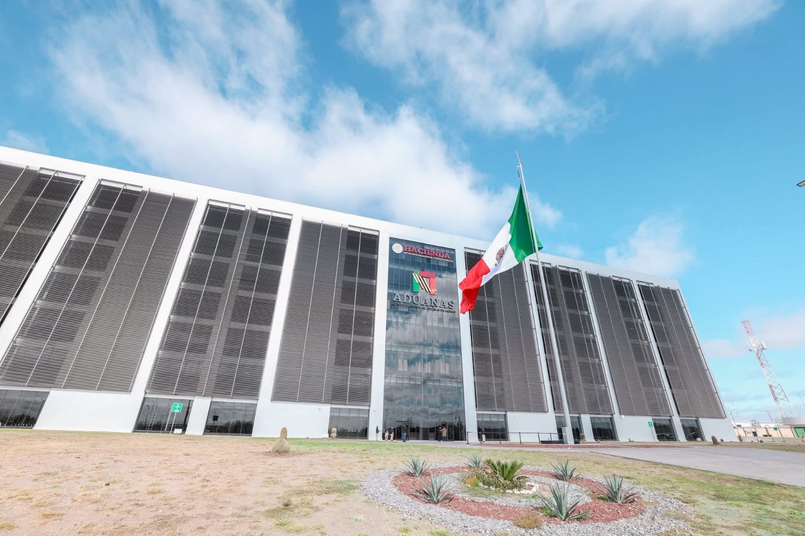 Edificio principal de la Agencia Nacional de Aduanas de Mxico en Nuevo Laredo con bandera de Mxico al frente y arquitectura moderna diseada para operaciones aduaneras
