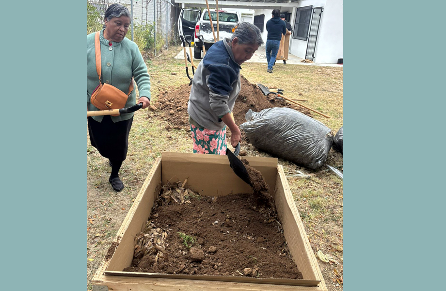 Vecinas rellenan con tierra y materia orgnica un cajn de cultivo durante la jornada de huertos urbanos