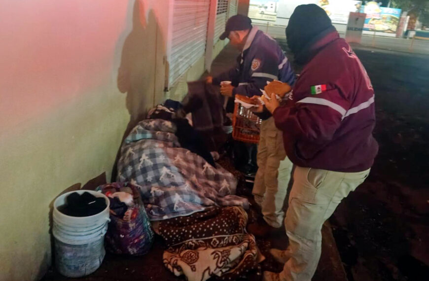 Personal de Protección Civil y Bomberos de Nuevo Laredo entrega cobijas, pan y café a una persona en situación de calle durante el Operativo Carrusel por bajas temperaturas.