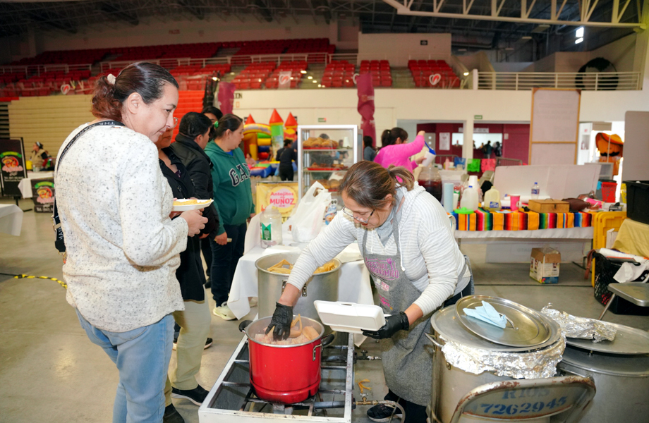 Expositora prepara tamales mientras asistentes esperan su turno durante el Tamal Fest en Nuevo Laredo