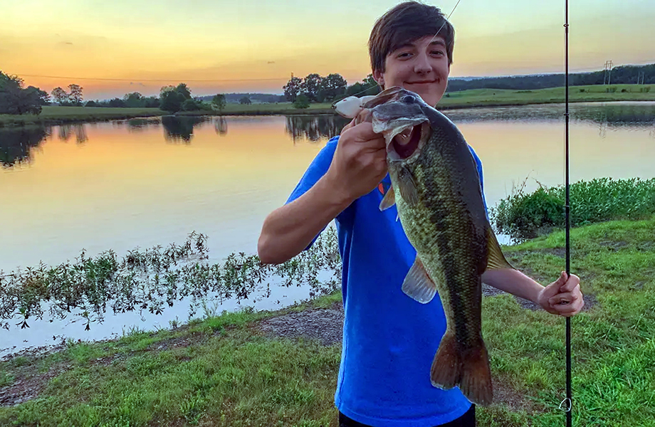 Joven muestra su captura durante jornada de pesca recreativa al atardecer, actividad que forma parte del impulso a la pesca deportiva en la región.