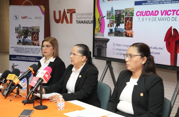 Three women in black blazers sit at a press conference table with microphones; banners behind show UAT Tamaulipas and Ciudad Victoria imagery.