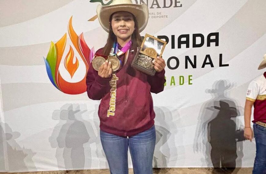 Young woman wearing a cowboy hat shows her medals and a trophy on stage at a sports award event.