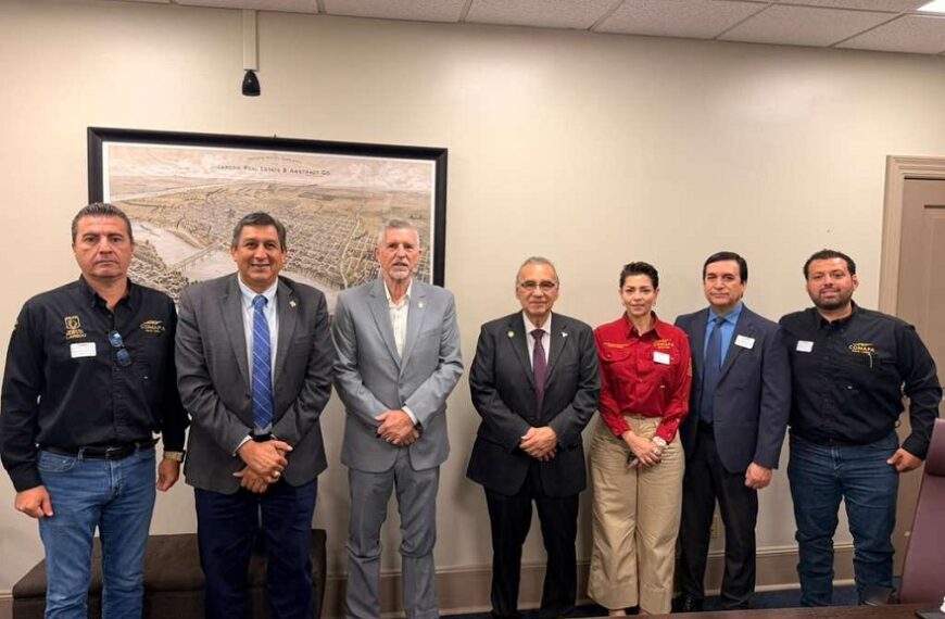 Seven professionals posing for a group photo in a conference room, dressed in business attire.