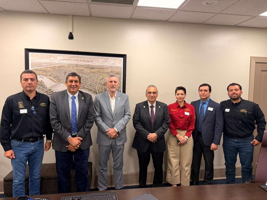 Seven professionals posing for a group photo in a conference room, dressed in business attire.